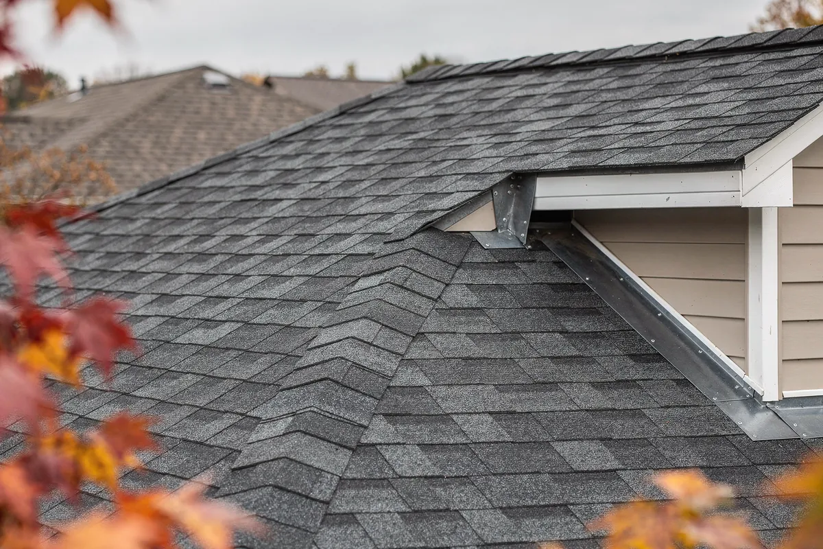 A closed cut valley and step flashing on a new grey shingle roof